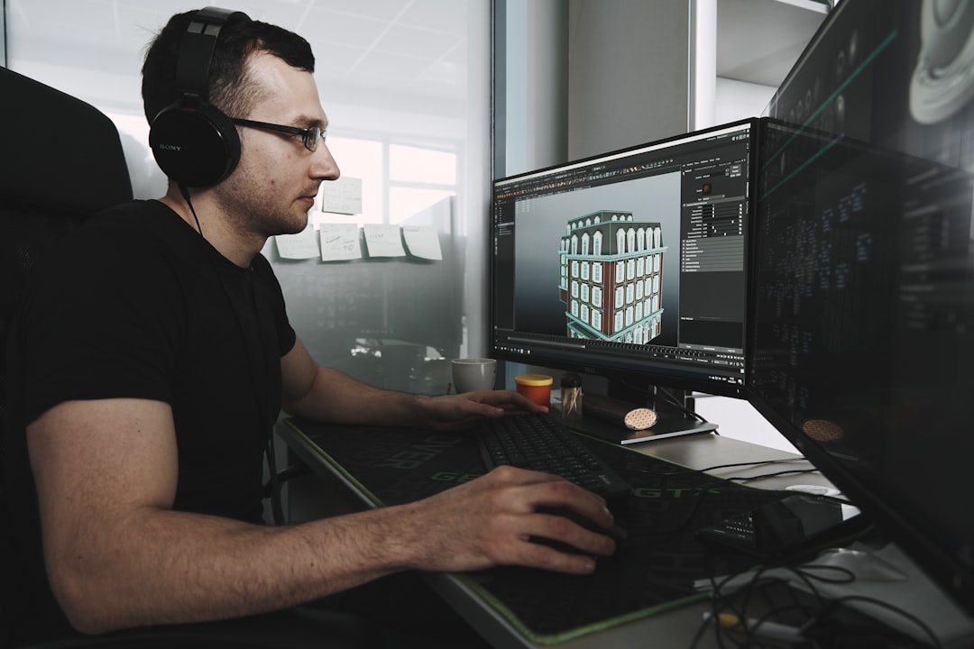 Man in black tank top wearing black sunglasses using computer